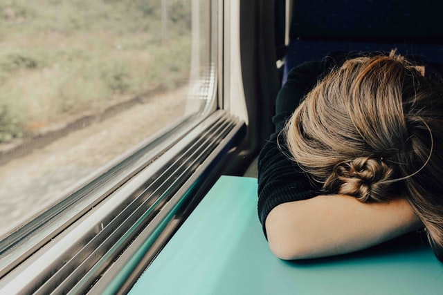 Woman Sleeping with Head Resting On Train Table