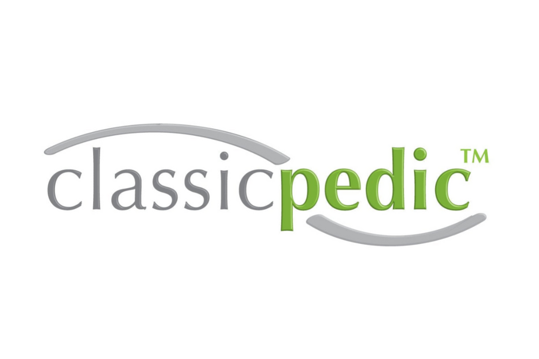 The logo for 'classic pedic' is displayed on a solid white background, featuring gray and green text with gray curved lines arching above and below.